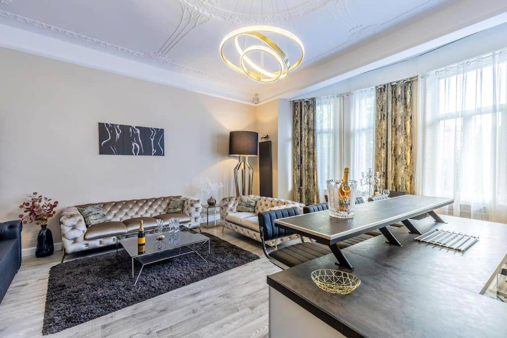 Salon spacieux avec canapés et lustre design - Appartement de luxe avec Jacuzzi au centre de Metz