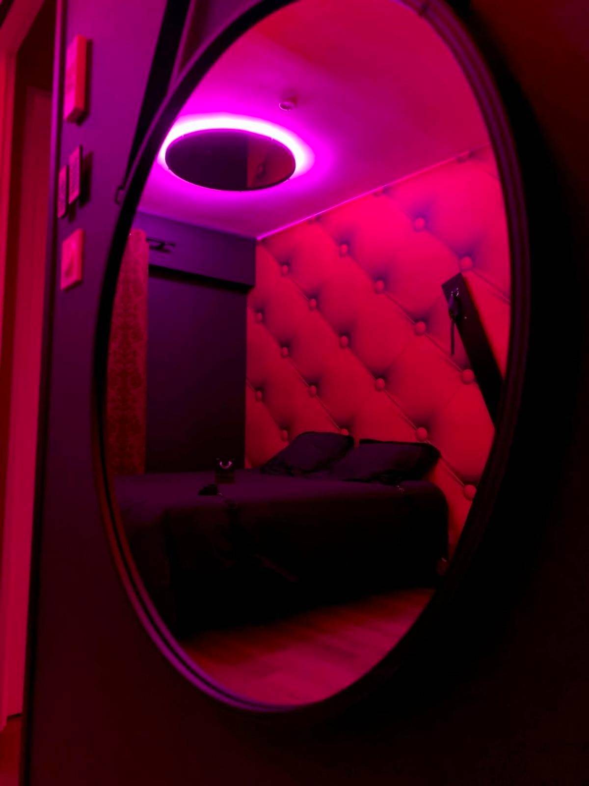 Miroir ovale reflétant un lit double - Love room avec jacuzzi privé