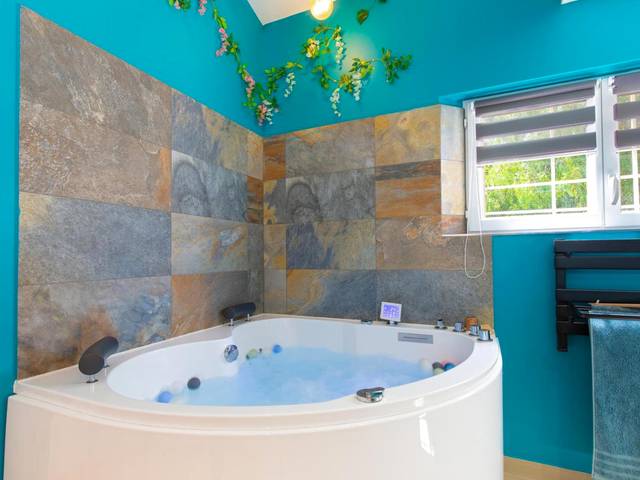 Jacuzzi d'angle dans salle de bain turquoise - Appartement Jacuzzi Love Room Jacuzzi