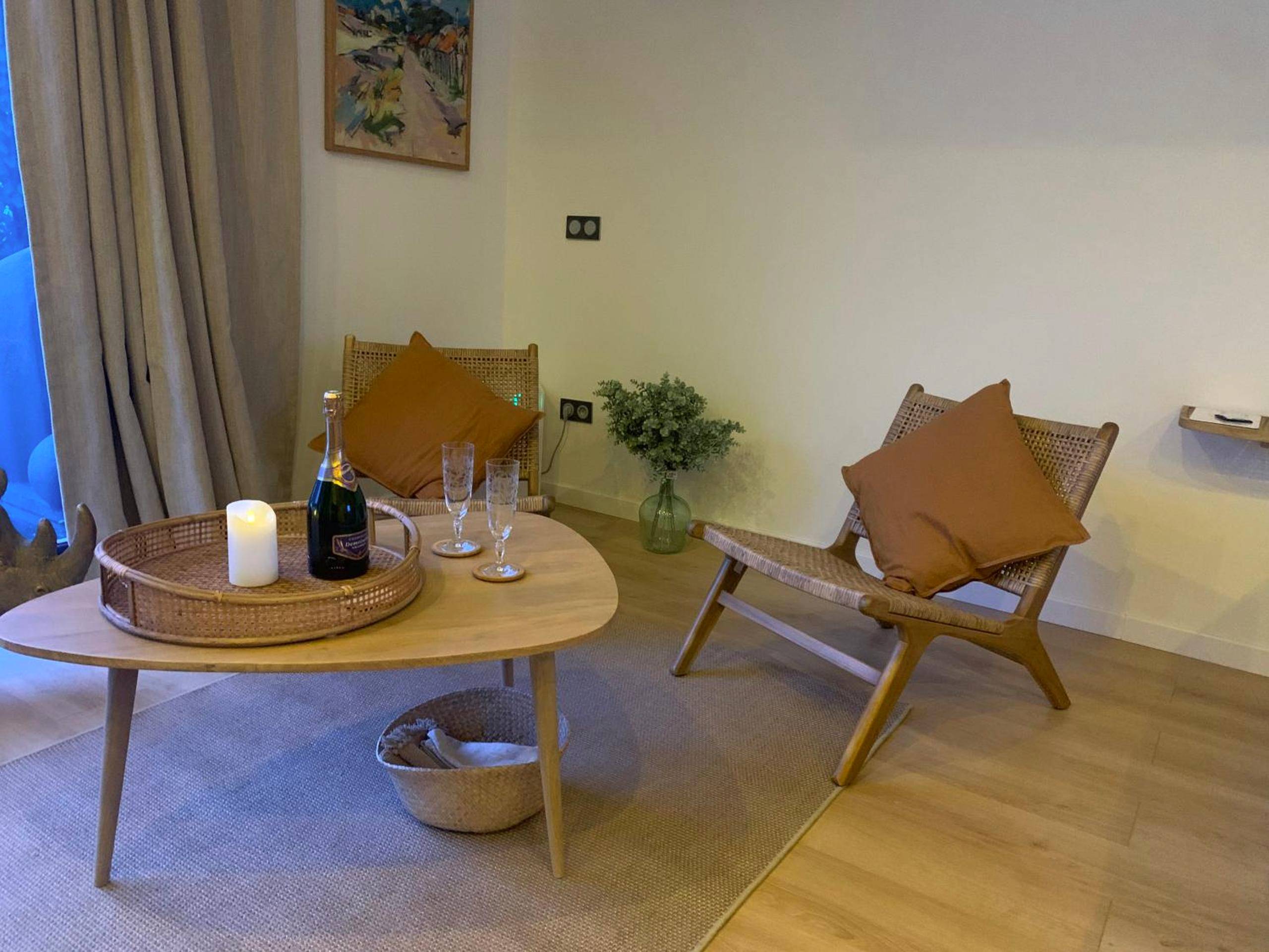 Espace salon avec champagne et fauteuils - Chambre romantique avec Jacuzzi privée