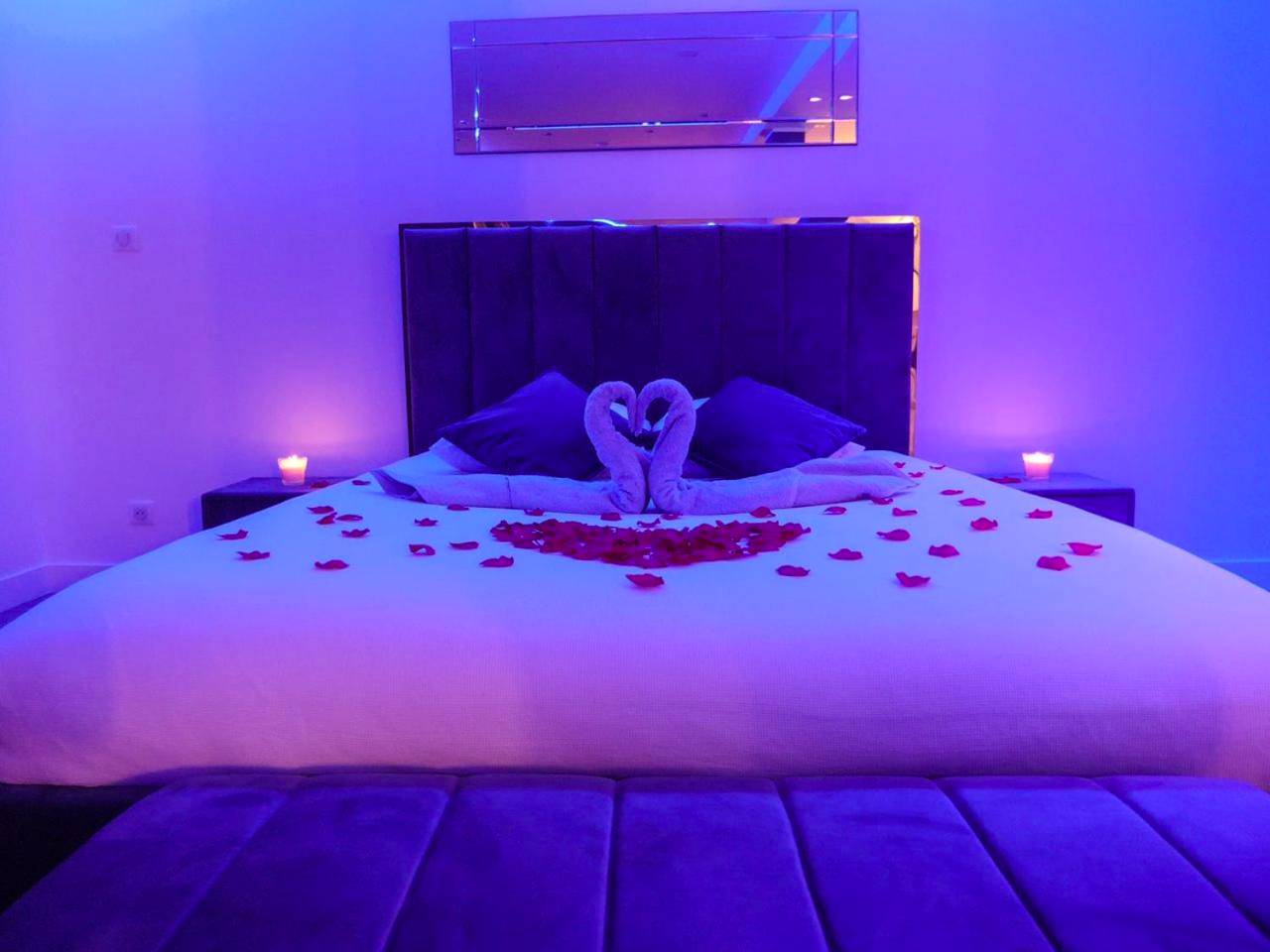 Lit king size décoré sous lumière violette - Appartement - Jacuzzi - Pour deux