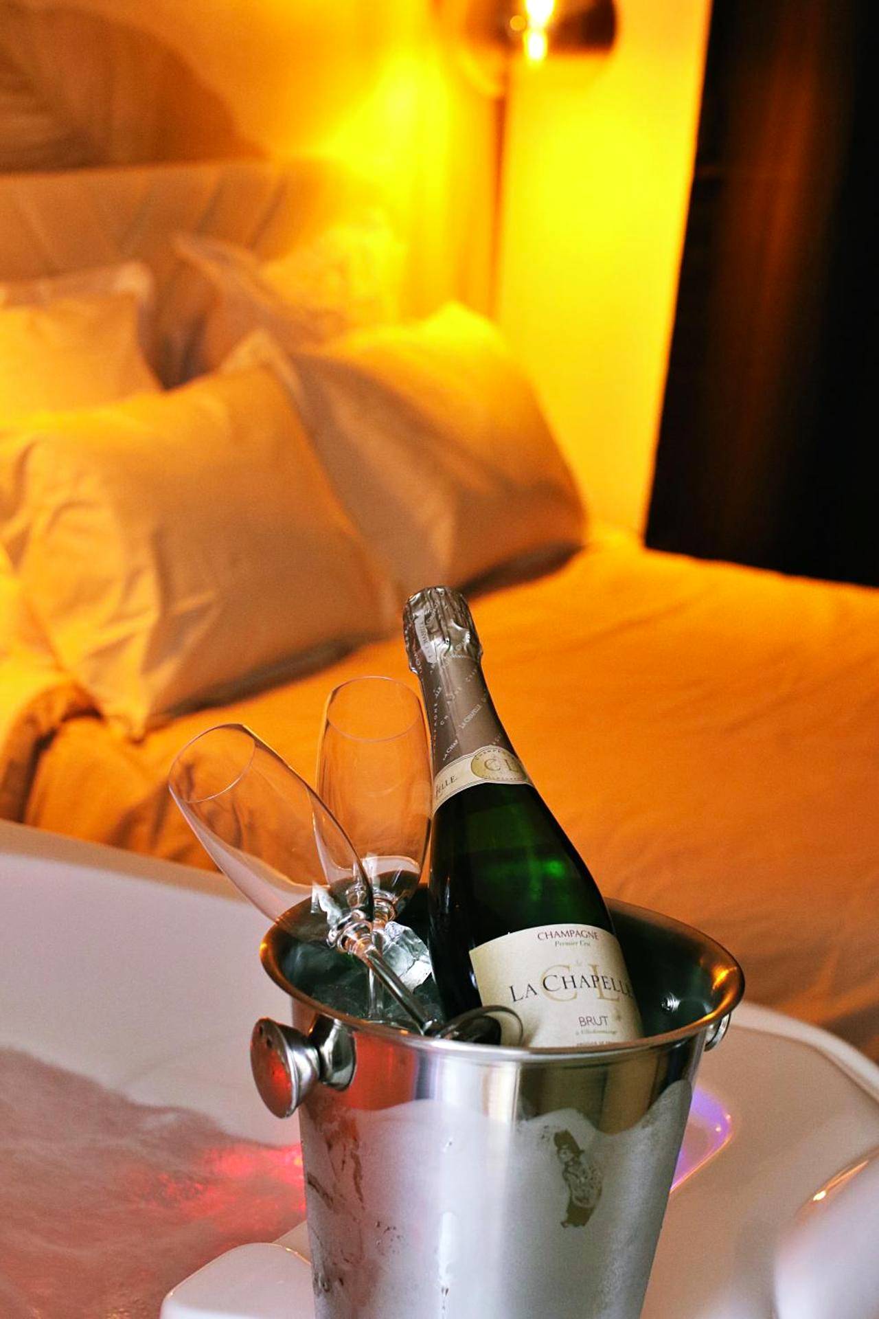 Bouteille de champagne et flûtes dans un seau - Love Room Roanne - Appartement luxueux avec Jacuzzi privatif