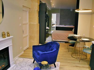 Salon avec fauteuil bleu et cheminée - Appartement luxueux avec Jacuzzi privatif