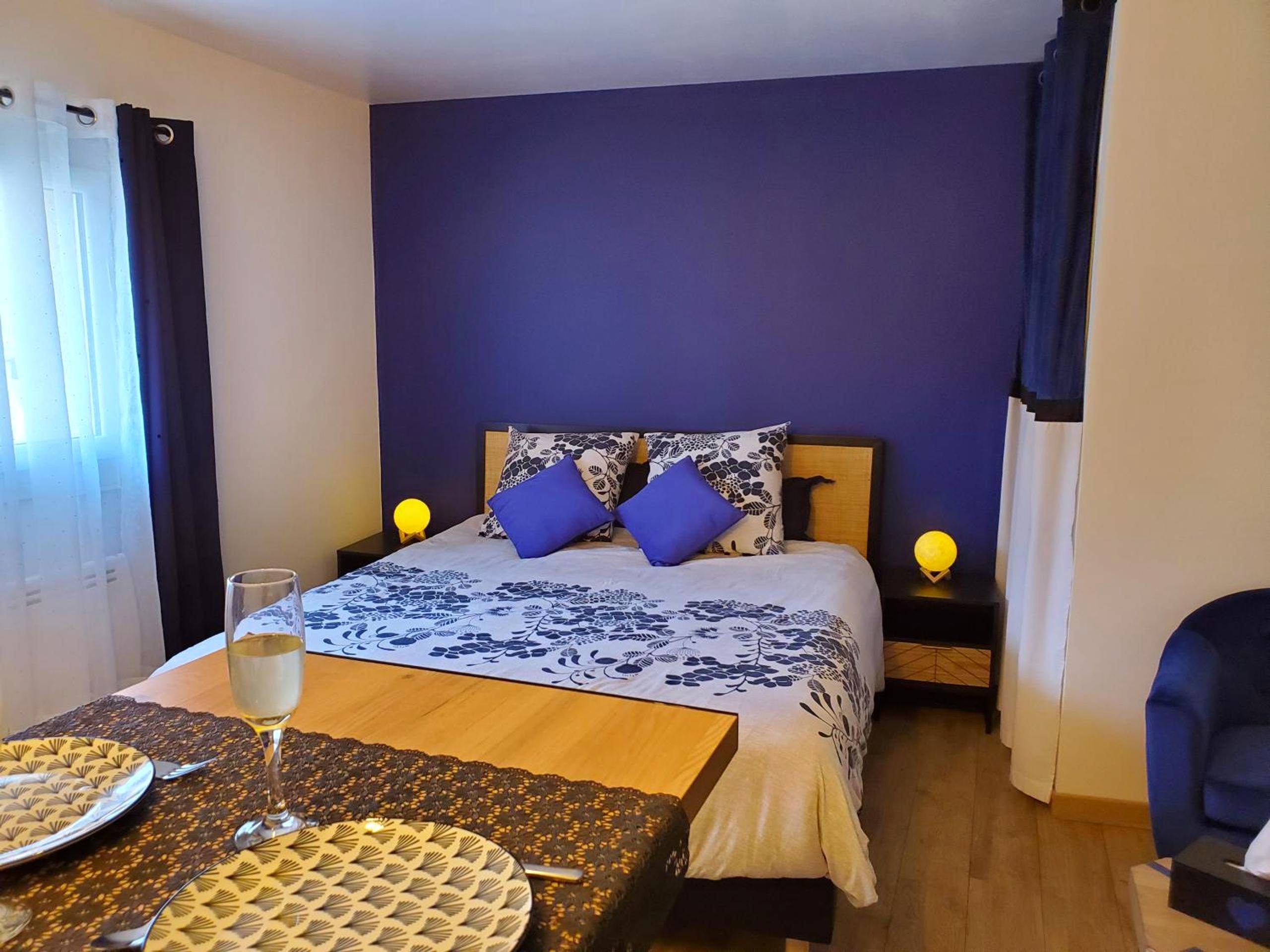 Lit double avec parure fleurie bleue et blanche - Jacuzzi privatif dans maison de village au calme