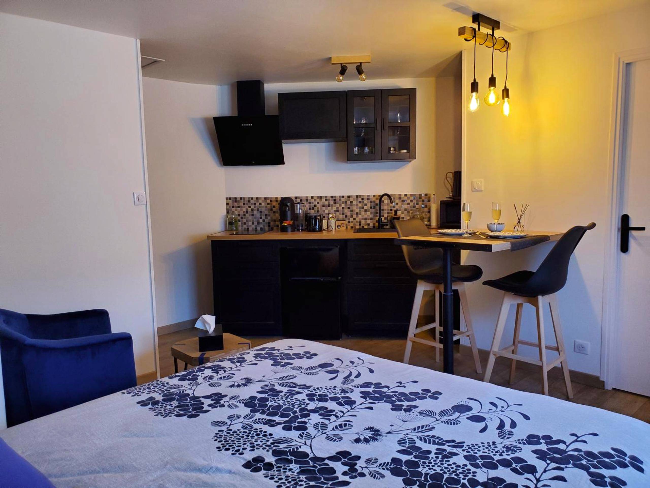 Cuisine équipée et coin repas avec tabourets - Jacuzzi privatif dans maison de village au calme