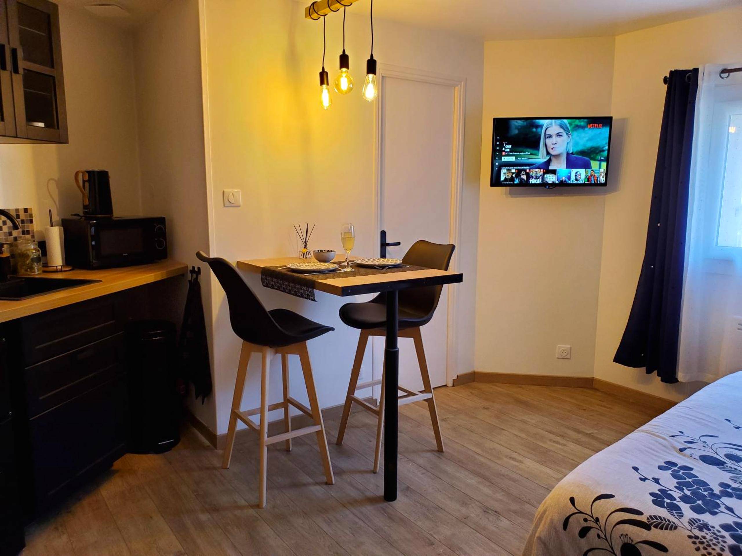 Espace repas avec table haute et télévision - Jacuzzi privatif dans maison de village au calme