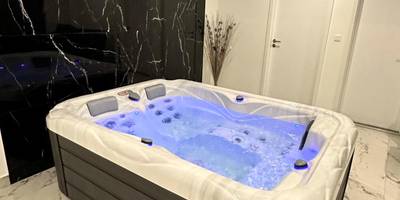 Jacuzzi avec éclairage bleu et mur en marbre - Appartement cosy jacuzzi spa 70M2