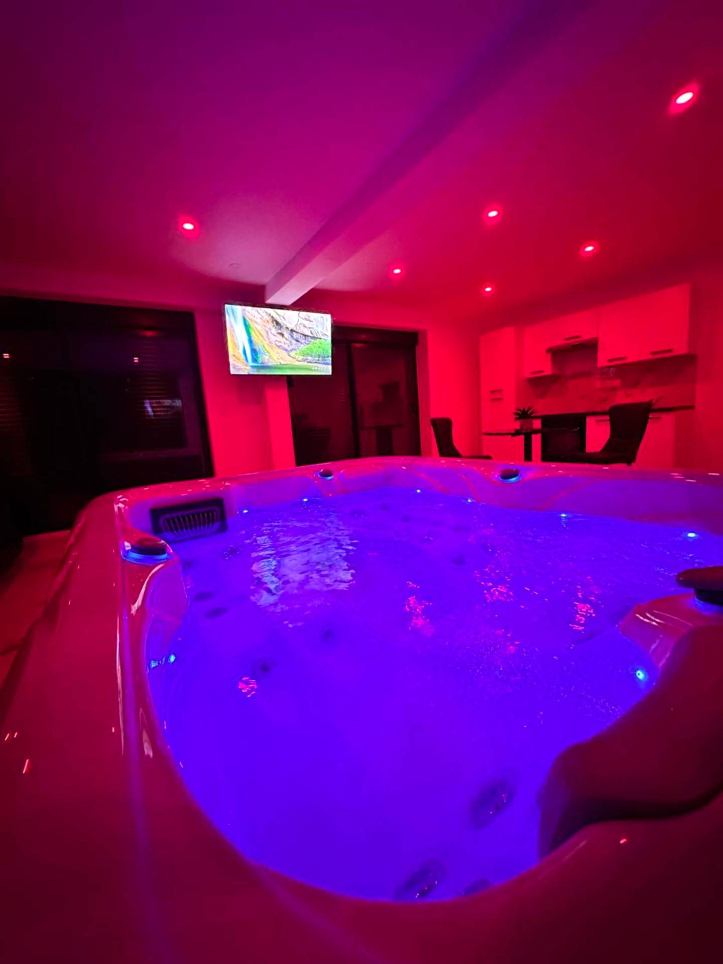 Jacuzzi illuminé sous une ambiance rose néon - Appartement cosy jacuzzi spa 70M2