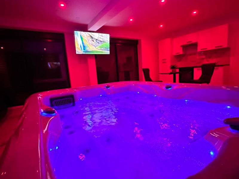 Jacuzzi illuminé sous une ambiance rose néon - Appartement cosy jacuzzi spa 70M2