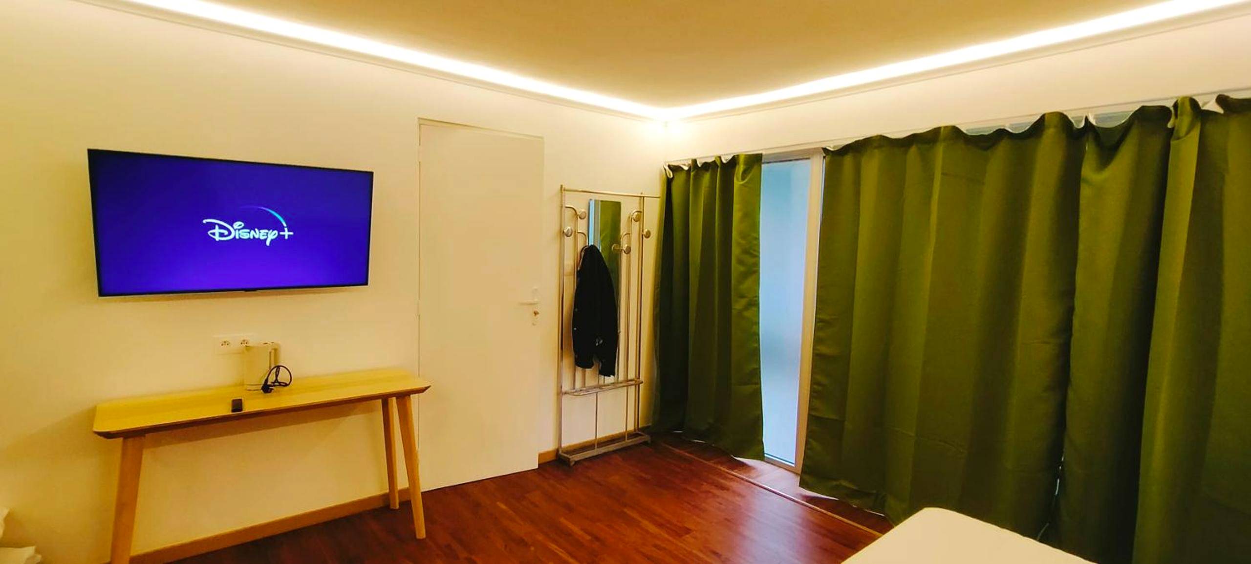 Écran plat mural et rideaux occultants verts - Jacuzzi LOVE Suite