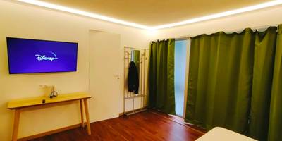 Écran plat mural et rideaux occultants verts - Jacuzzi LOVE Suite