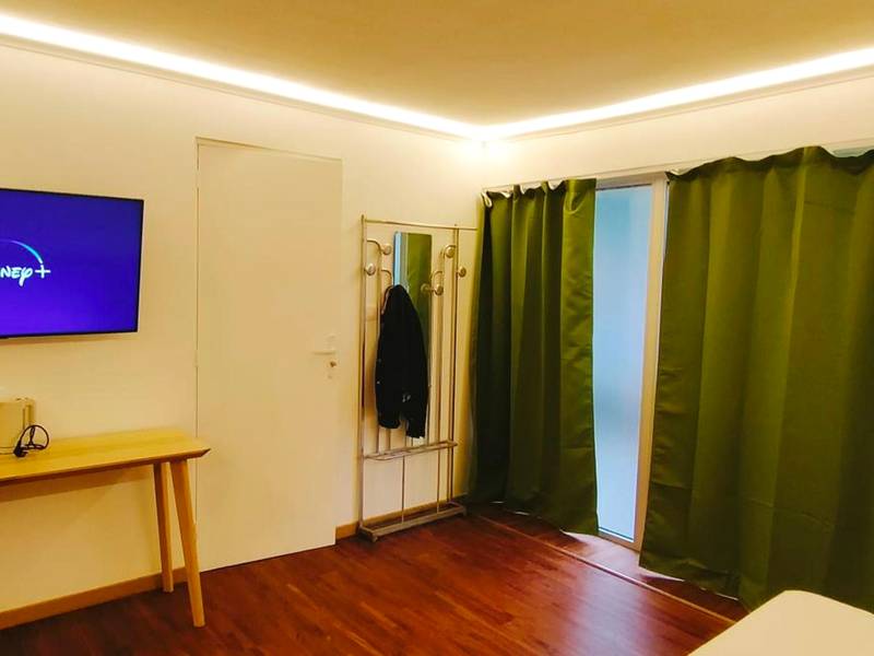 Écran plat mural et rideaux occultants verts - Jacuzzi LOVE Suite