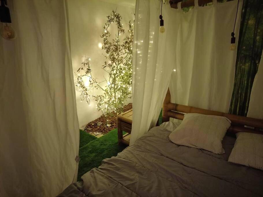 Espace nuit avec décor végétal et guirlandes - Le Jardin d'Eden - Appartement de charme avec Sauna, Hammam, spa