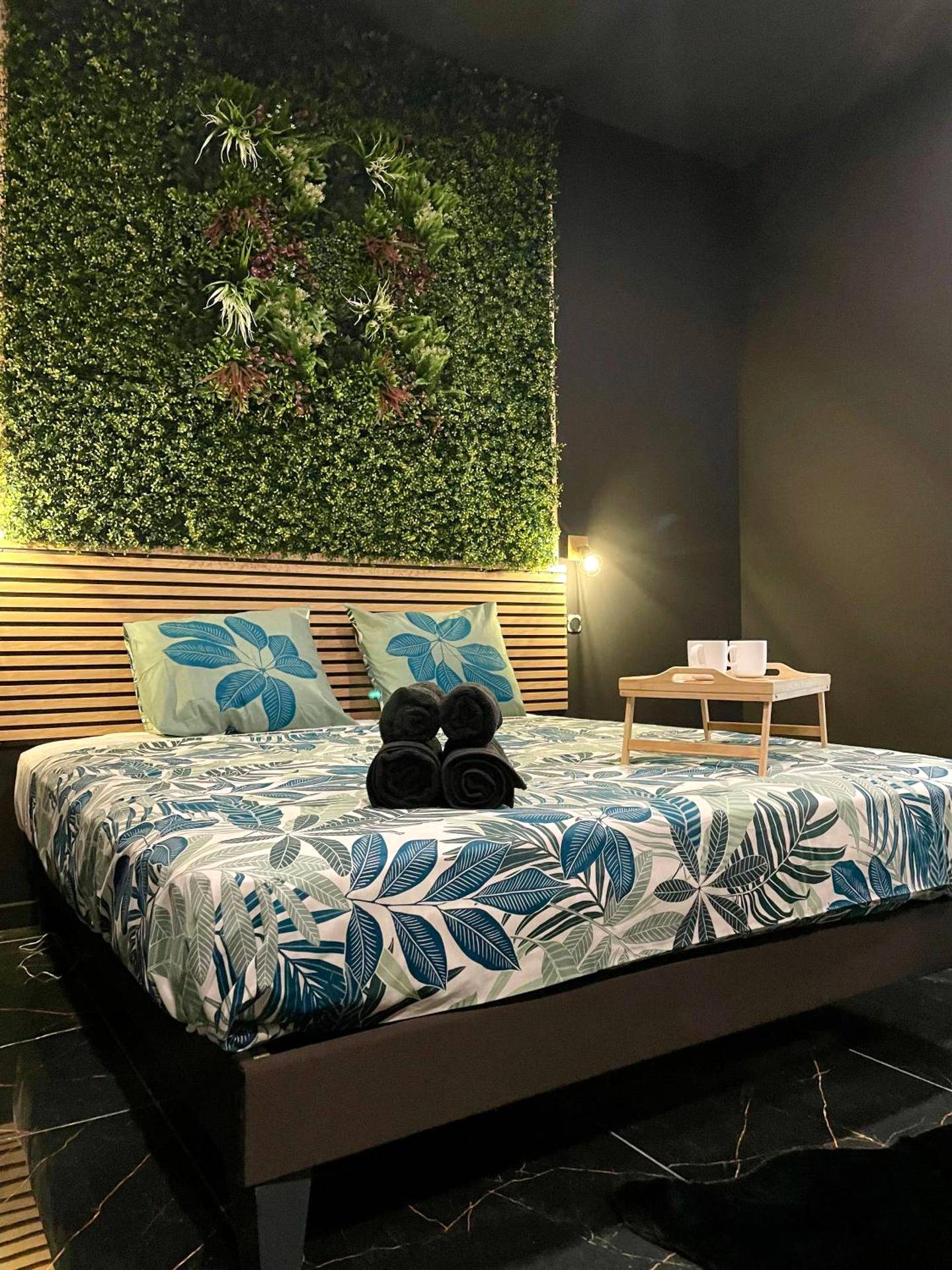 Lit double avec mur végétal et plateau petit - déjeuner - Jungle Love Room de l Hermitage