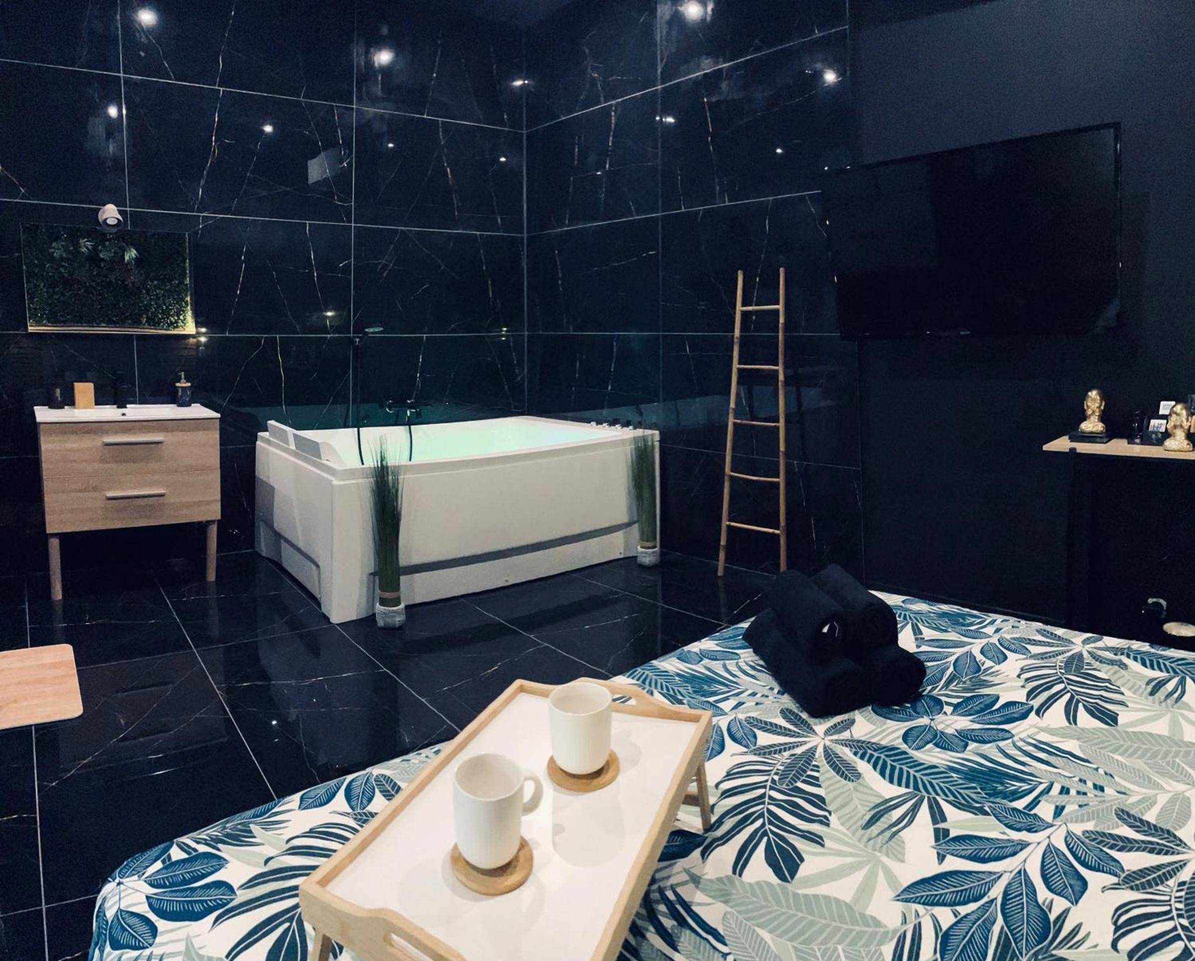Baignoire balnéo dans salle de bain design noire - Jungle Love Room de l Hermitage
