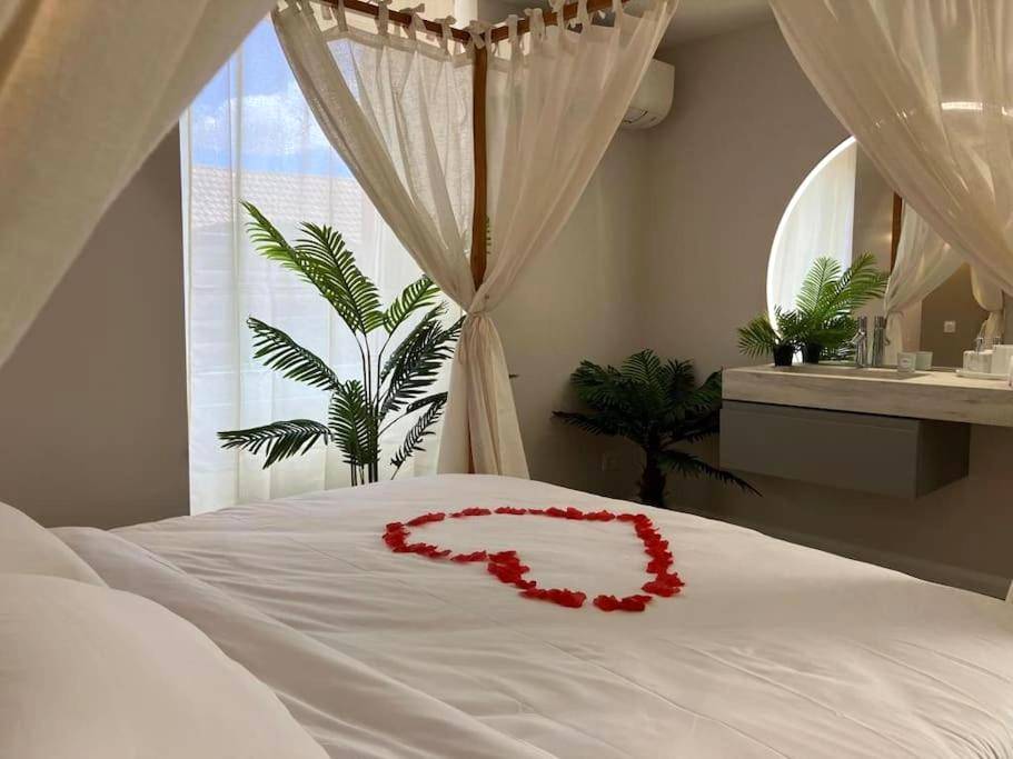 Lit à baldaquin avec cœur en pétales de roses - Jungle Secret SPA Nuit insolite