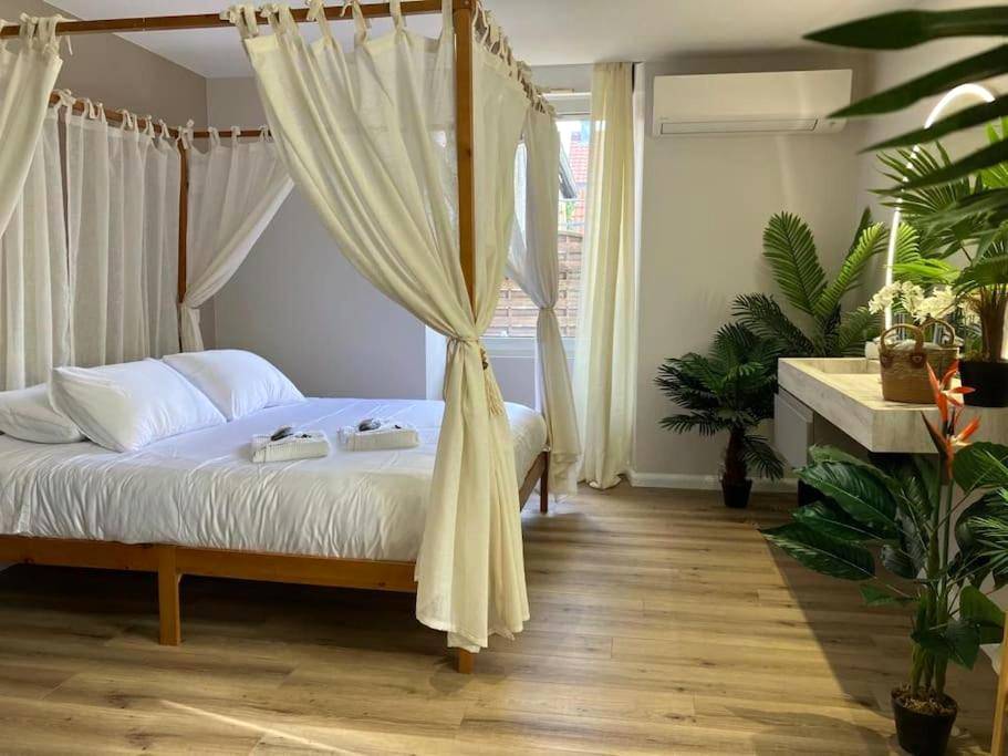 Chambre avec lit à baldaquin et plantes vertes - Jungle Secret SPA Nuit insolite