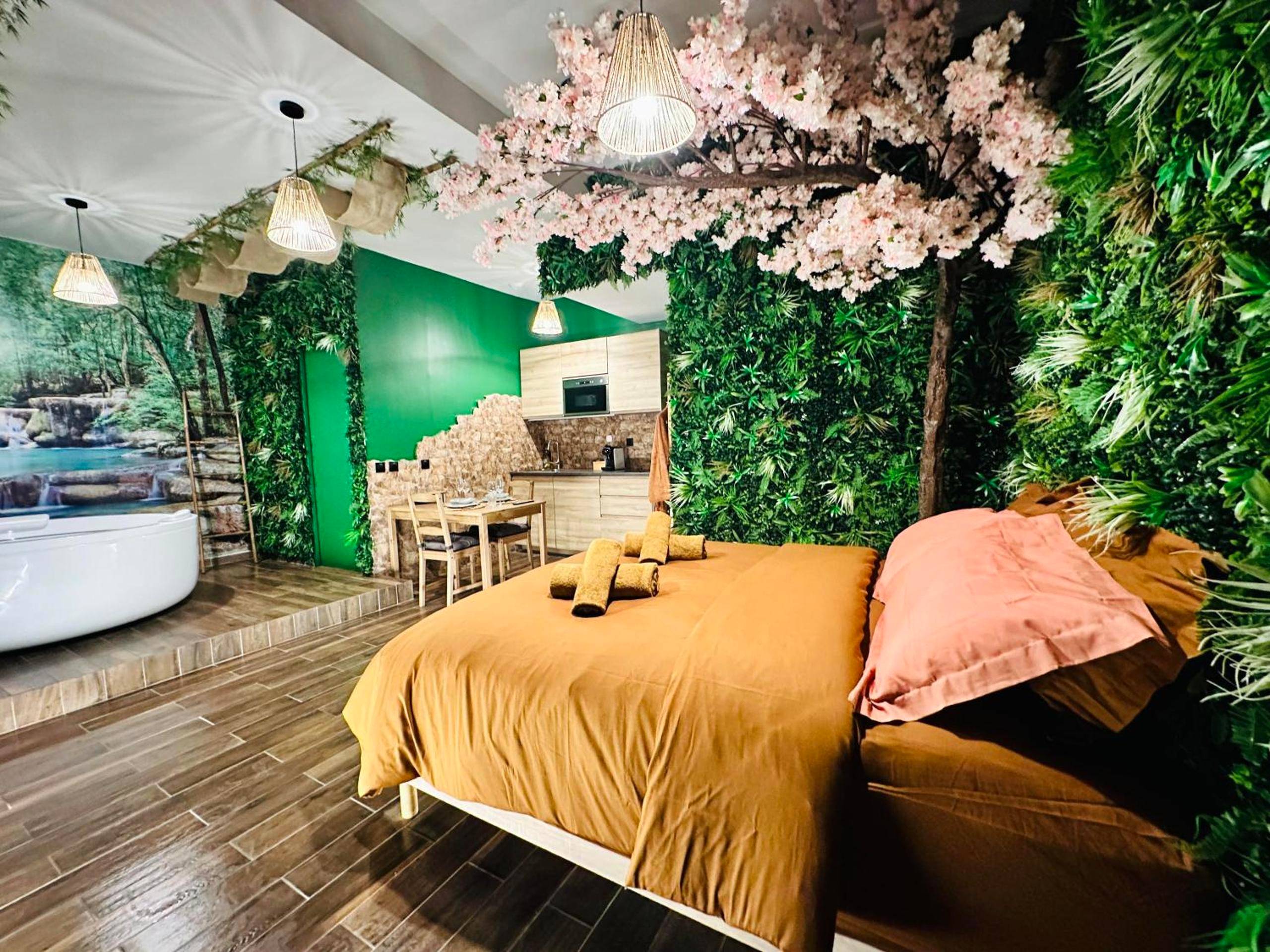 Lit double avec serviettes et mur végétal - JUNGLE SUITE - Jacuzzi - Centre - Clim by Narbana