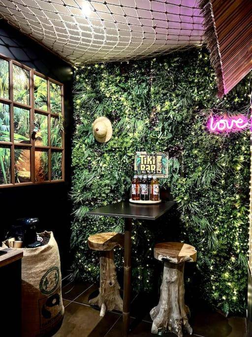 Espace bar Tiki avec tabourets en bois sculpté - La Jungle de Zoé - Nuit insolite à 15min de Caen