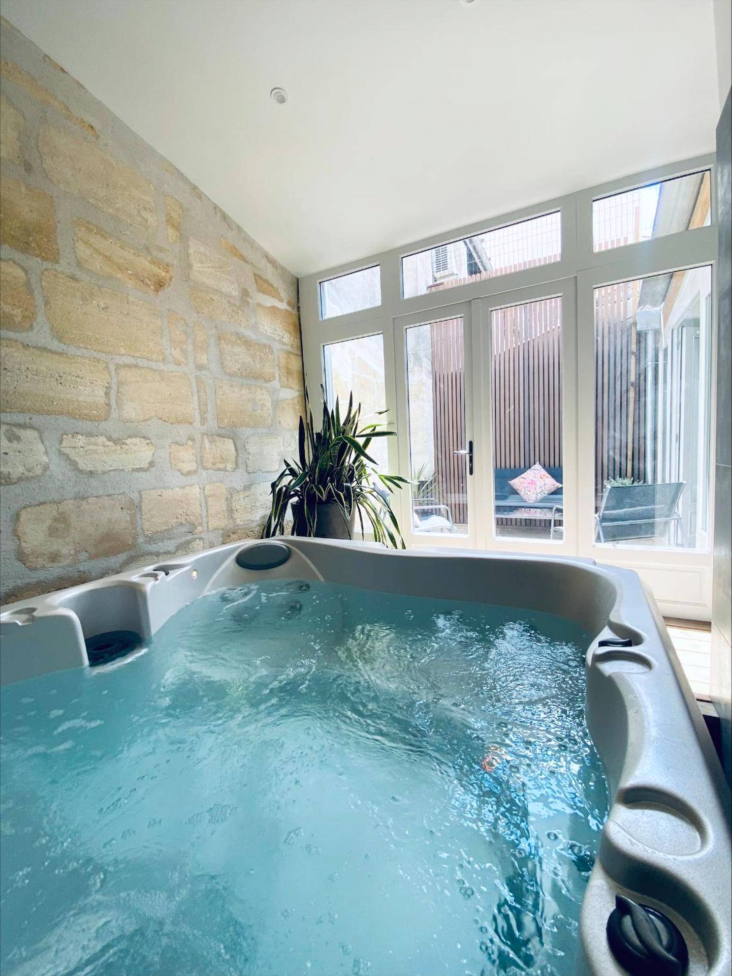 Jacuzzi intérieur face à une baie vitrée - Love Room Bordeaux - La King Le 50 Suites and SPA