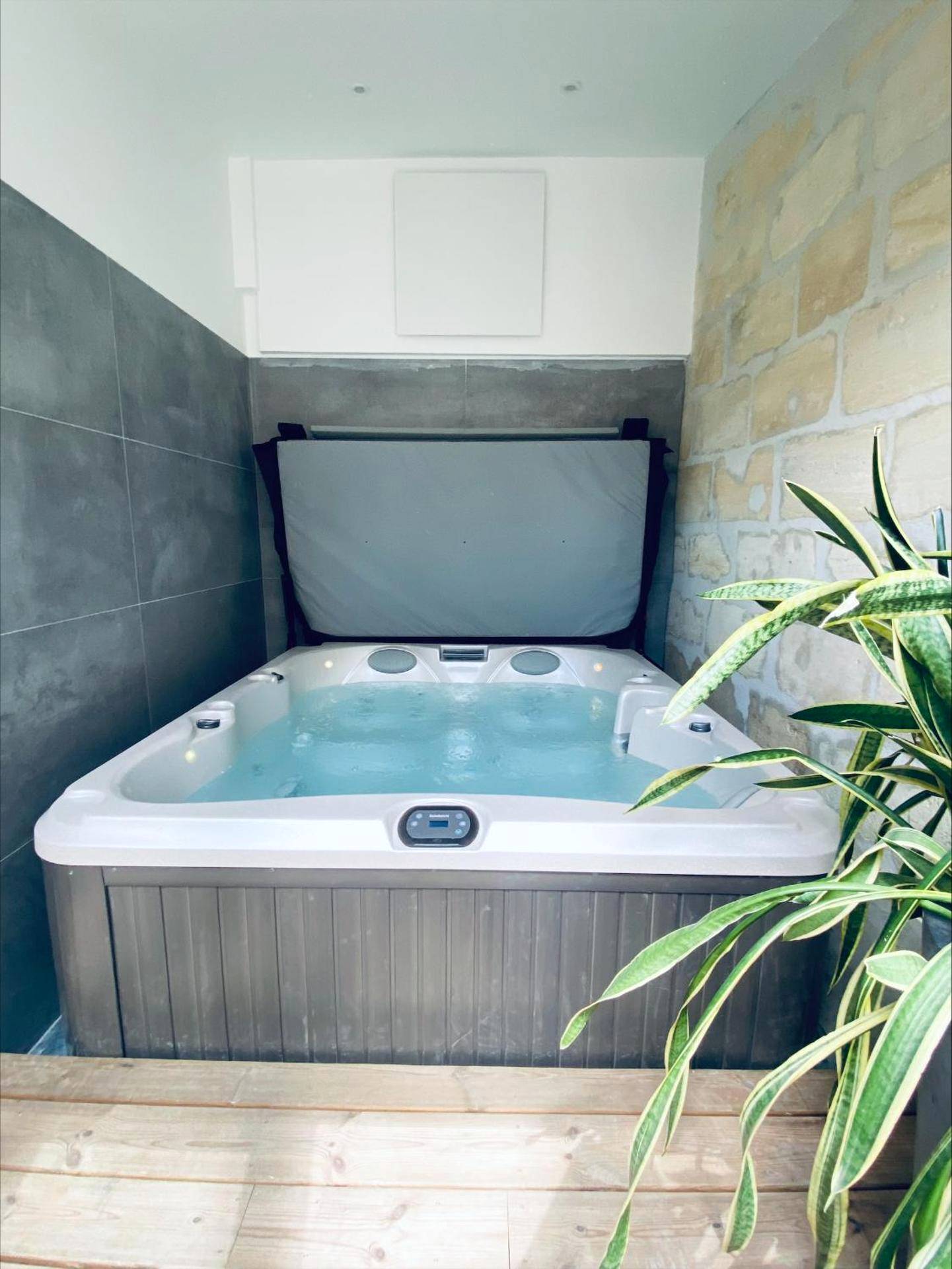 Jacuzzi moderne entre pierre et carrelage - La King Le 50 Suites and SPA