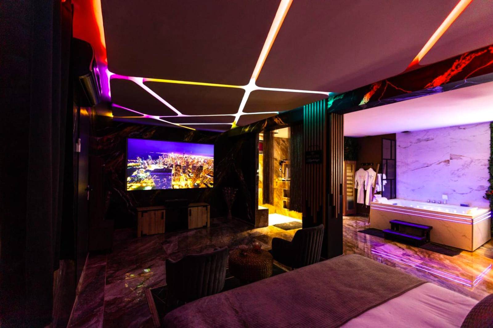 Espace nuit avec grand écran et jacuzzi - Krystalisya Room Suite Spa Privatif Sauna Jacuzzi Siege Massant