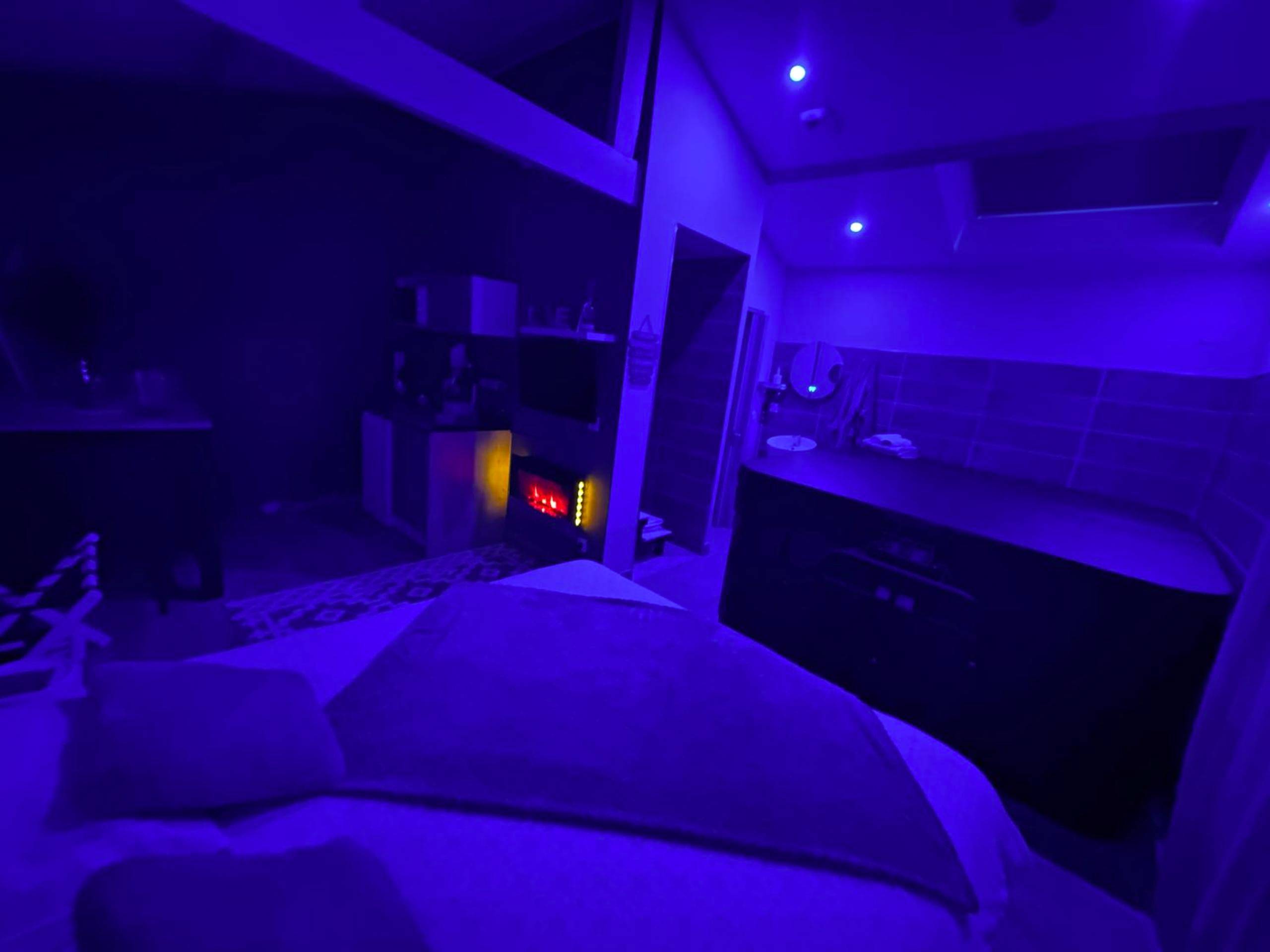 Ambiance nocturne avec lumières bleues et lit - Laloveroom