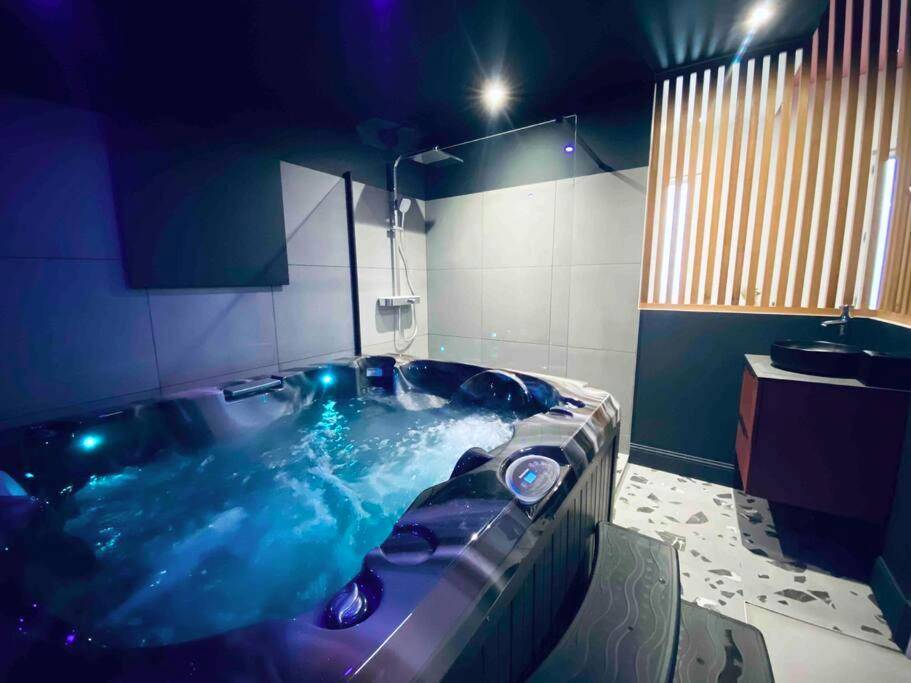 Jacuzzi éclairé en bleu et douche à l'italienne - La Litchi Le 50 Suites and Spa centre ville