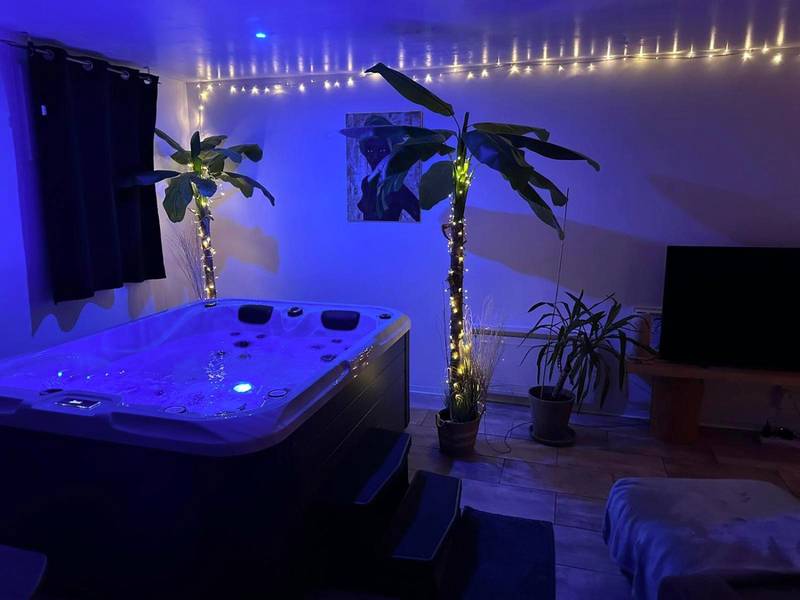 Jacuzzi privatif avec éclairage bleu et palmiers - Love Room Fagnières - Loft en Champagne