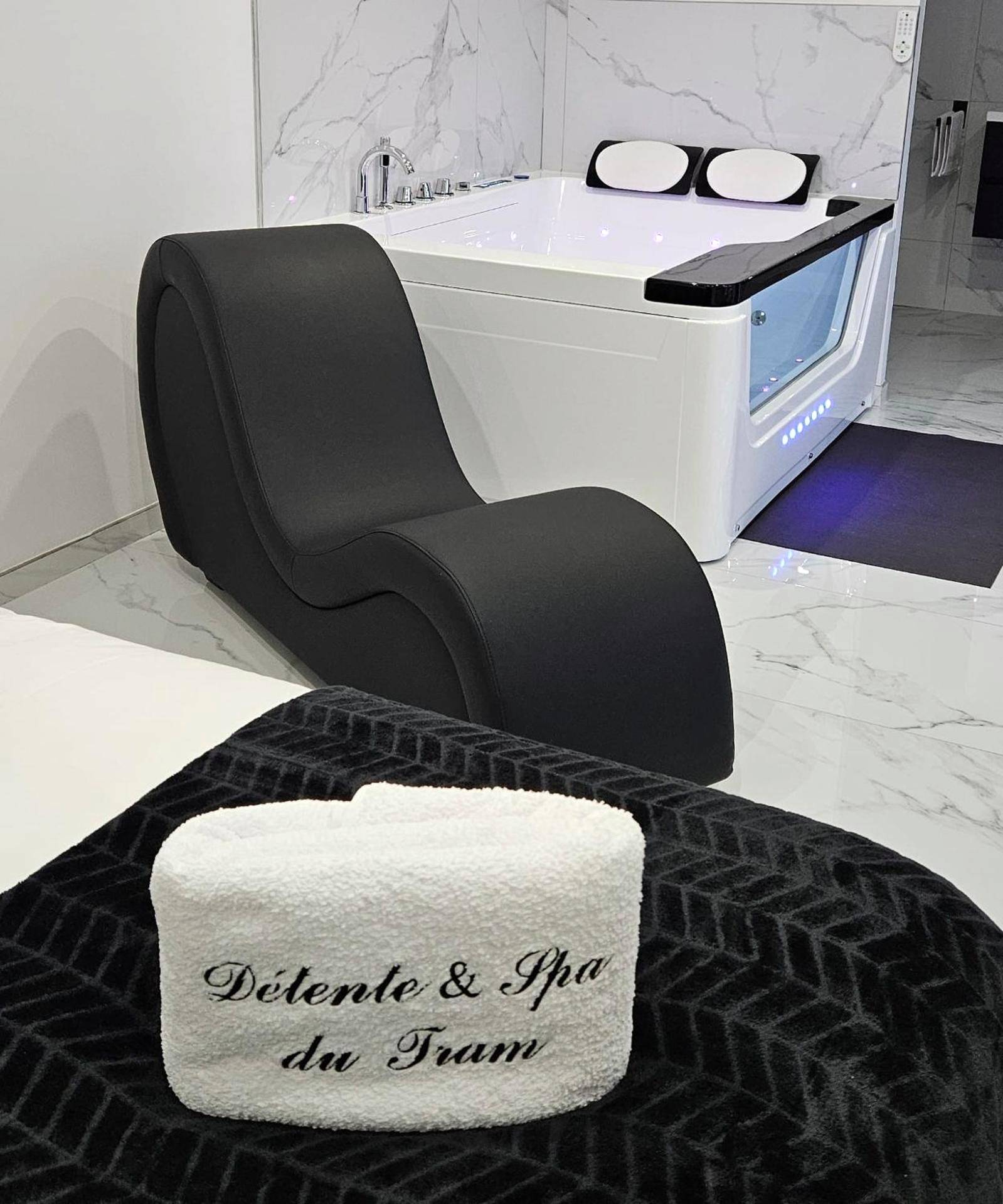 Fauteuil tantra noir et jacuzzi avec hublot - Love Room Ronchamp - Loft Détente & Spa du Tram