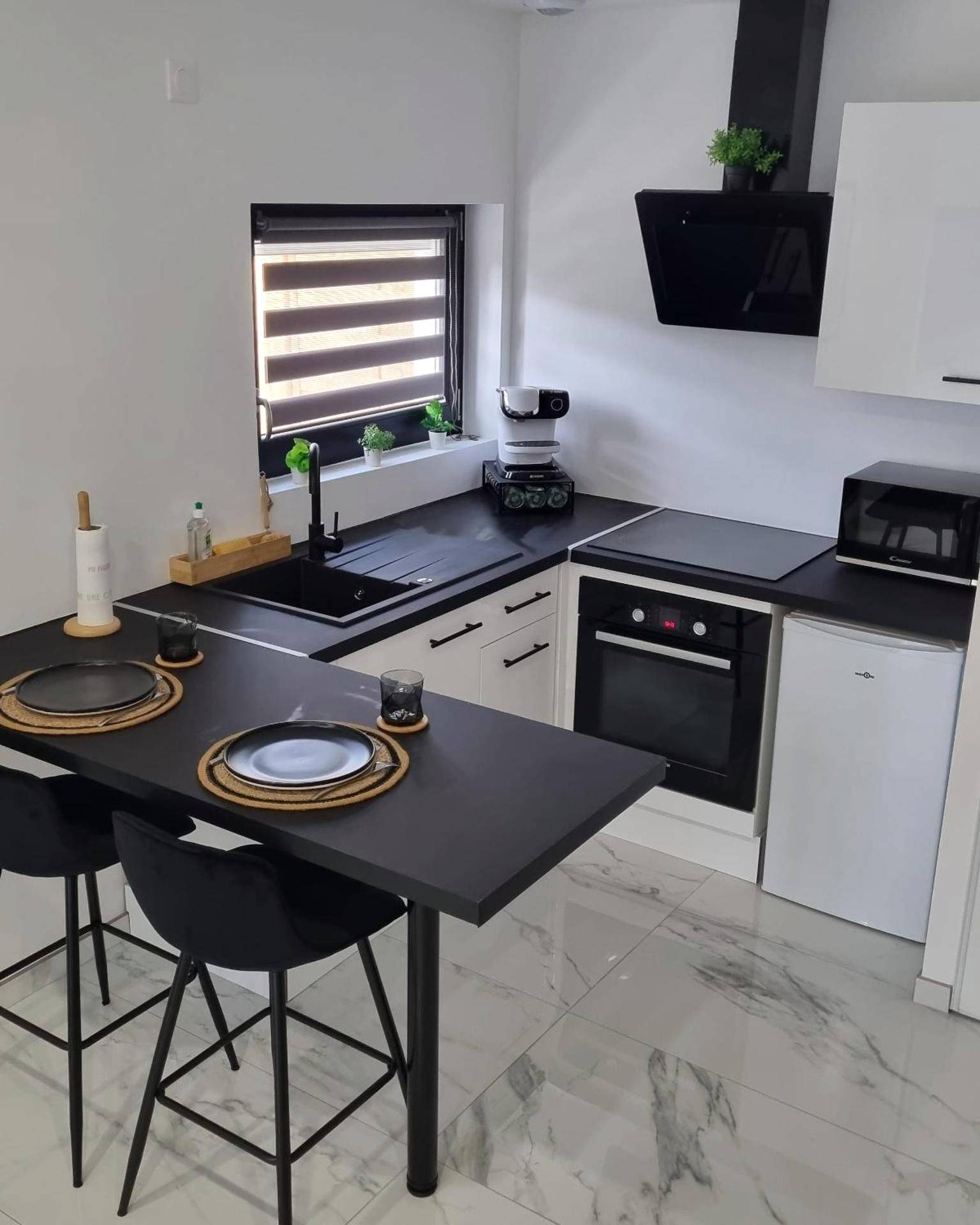 Cuisine équipée moderne avec coin repas noir - Loft Détente & Spa du Tram