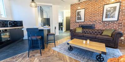 Salon industriel avec mur en briques et canapé - Jacuzzi - Nice quartier des musiciens - Loft