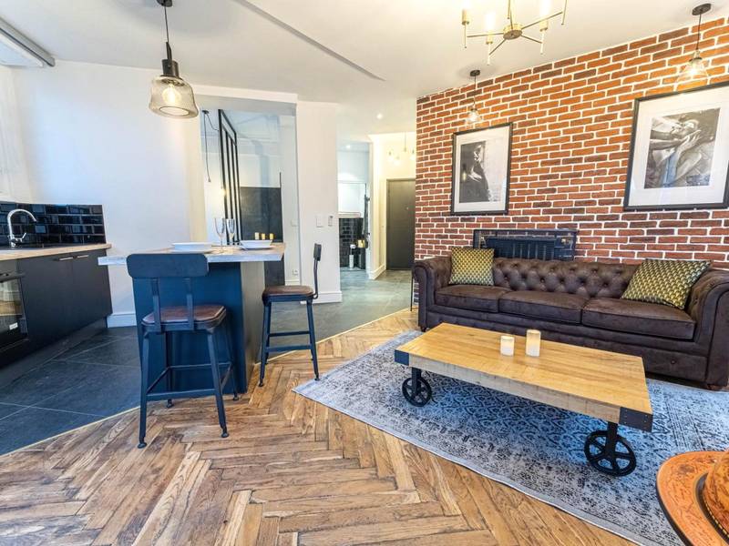 Salon industriel avec mur en briques et canapé - Jacuzzi - Nice quartier des musiciens - Loft