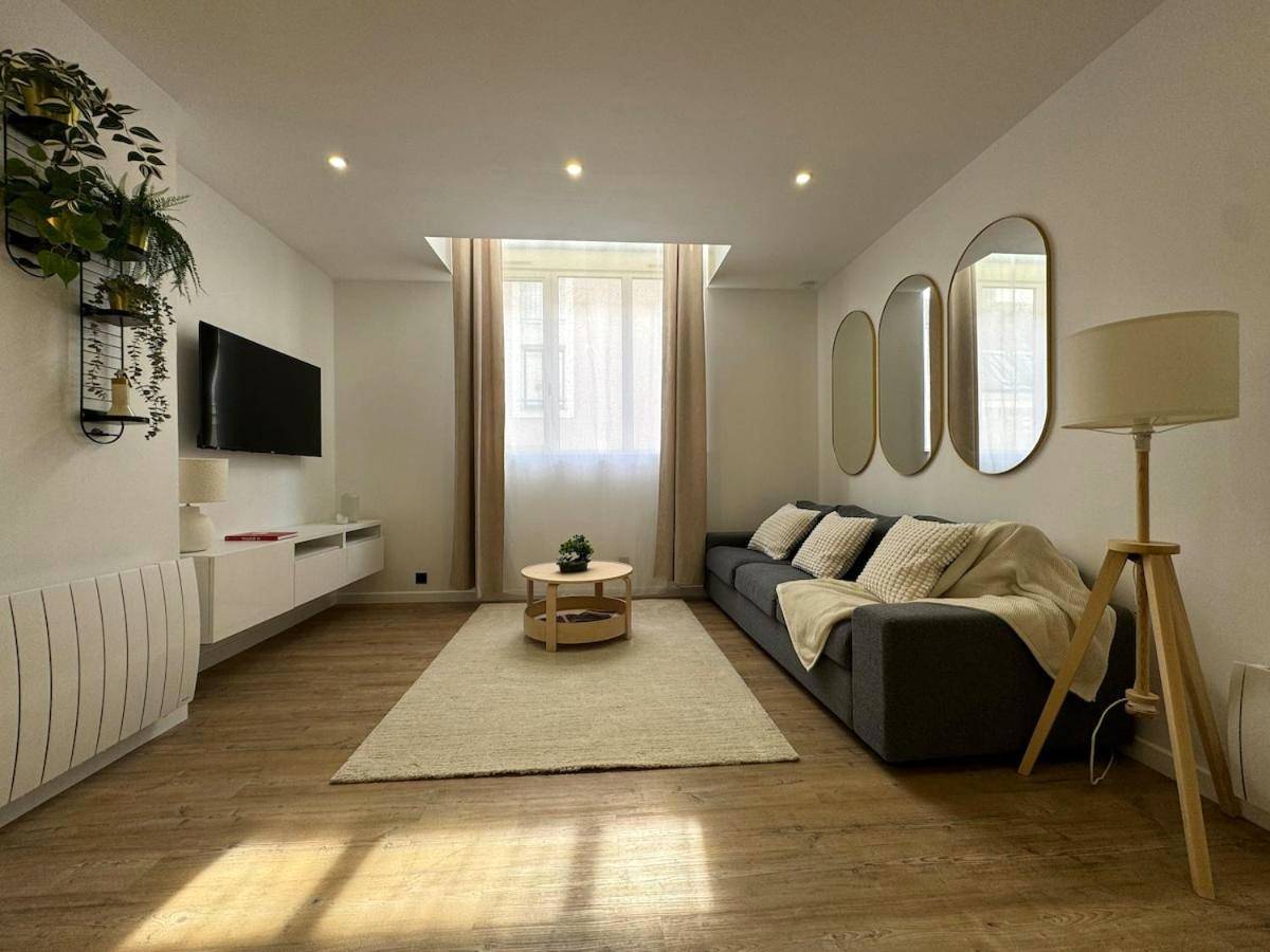 Salon avec canapé gris et miroirs ovales - Loft avec Jaccuzi