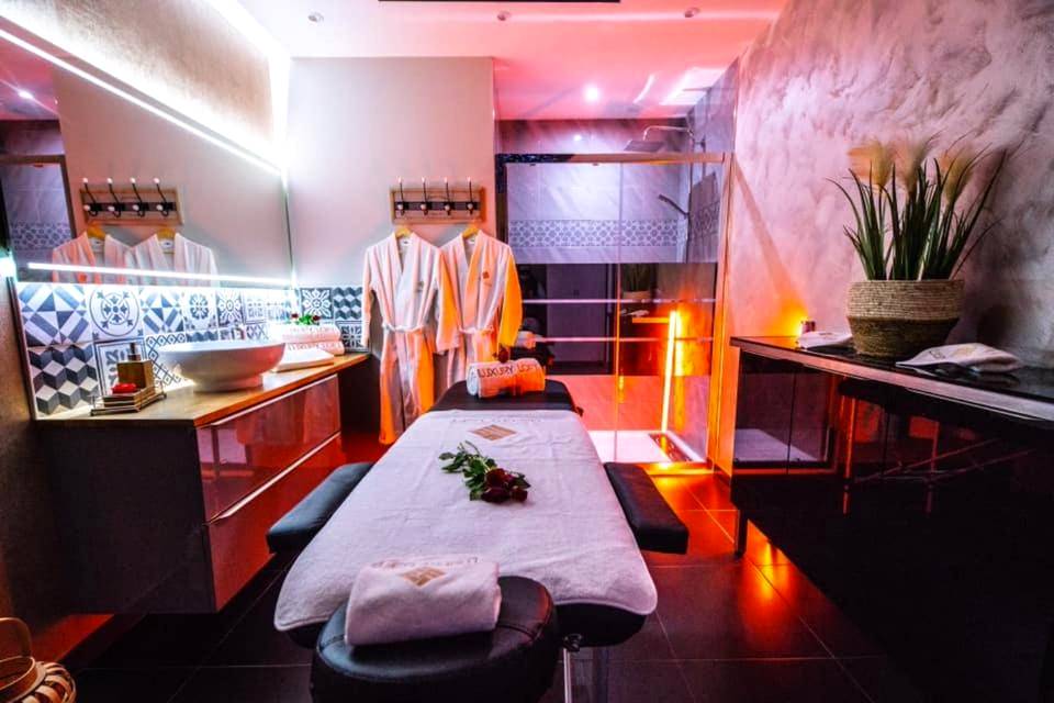 Table de massage avec peignoirs et roses - Loft privatif avec jacuzzi et sauna