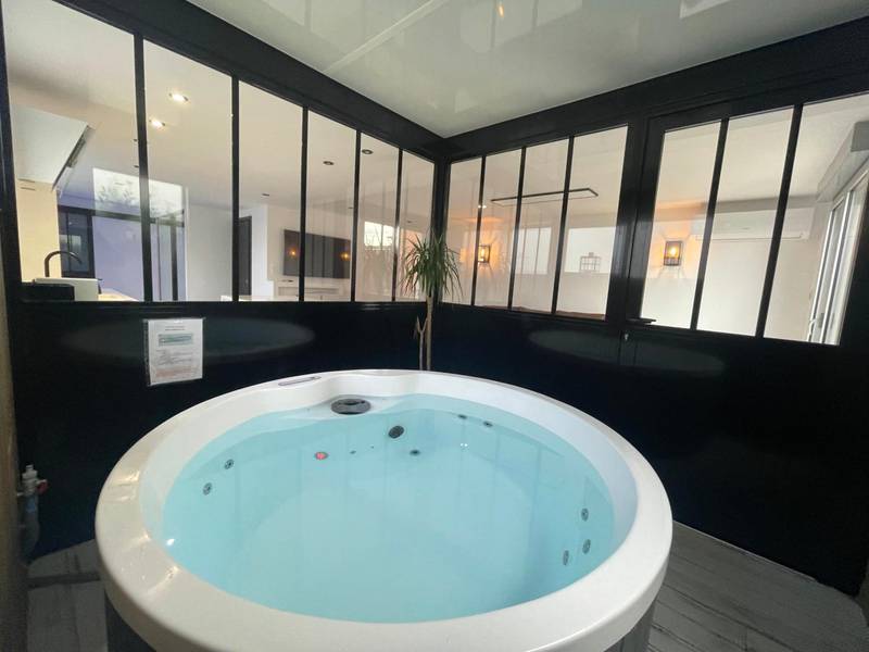 Jacuzzi rond intégré dans une verrière noire - Love Room Saint - Cyprien - Loft red lights