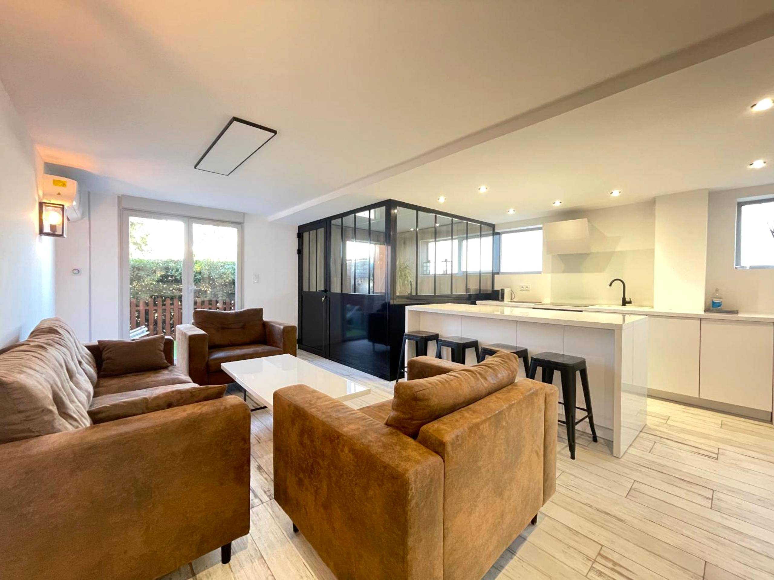 Salon ouvert avec canapés et cuisine équipée - Loft red lights