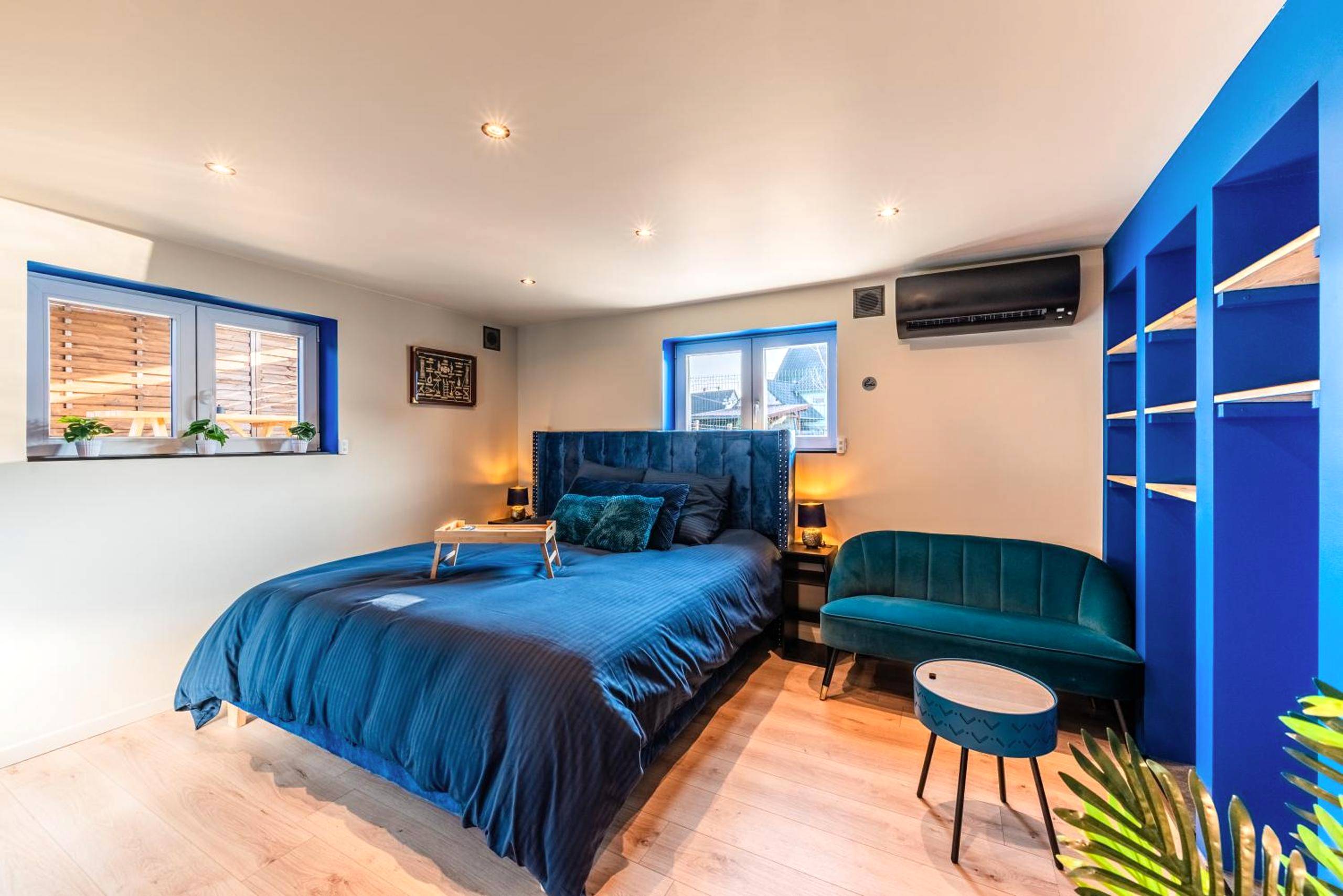 Chambre avec lit king size et canapé bleu - Loft SPA privatif 2 - 4 pers - Jacuzzi & Sauna près de Strasbourg