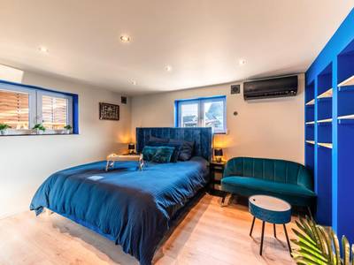 Chambre avec lit king size et canapé bleu - Loft SPA privatif 2 - 4 pers - Jacuzzi & Sauna près de Strasbourg