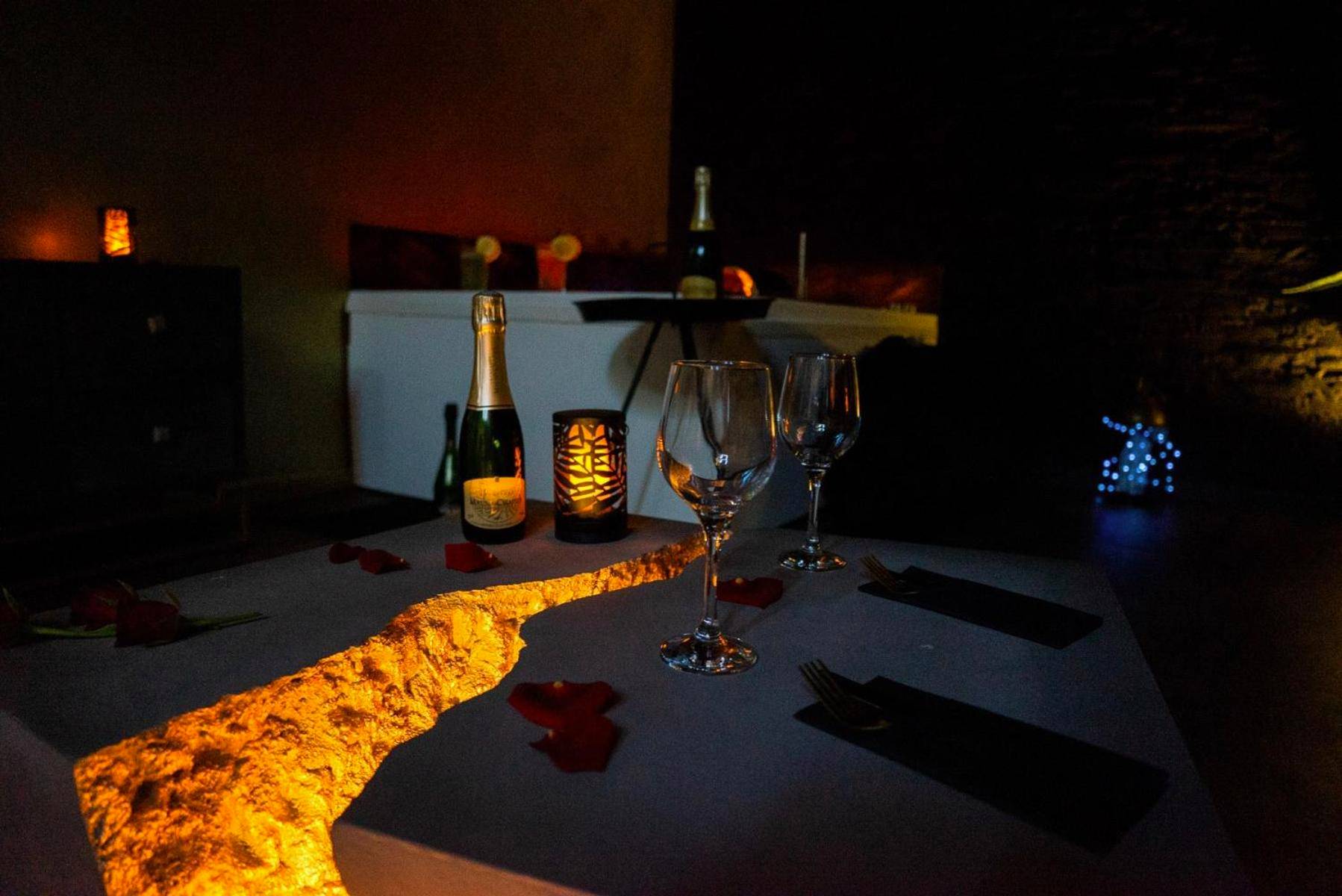 Table basse lumineuse avec verres et pétales - LOVE Suites & SPA "Le Loft" avec Jacuzzi privatif