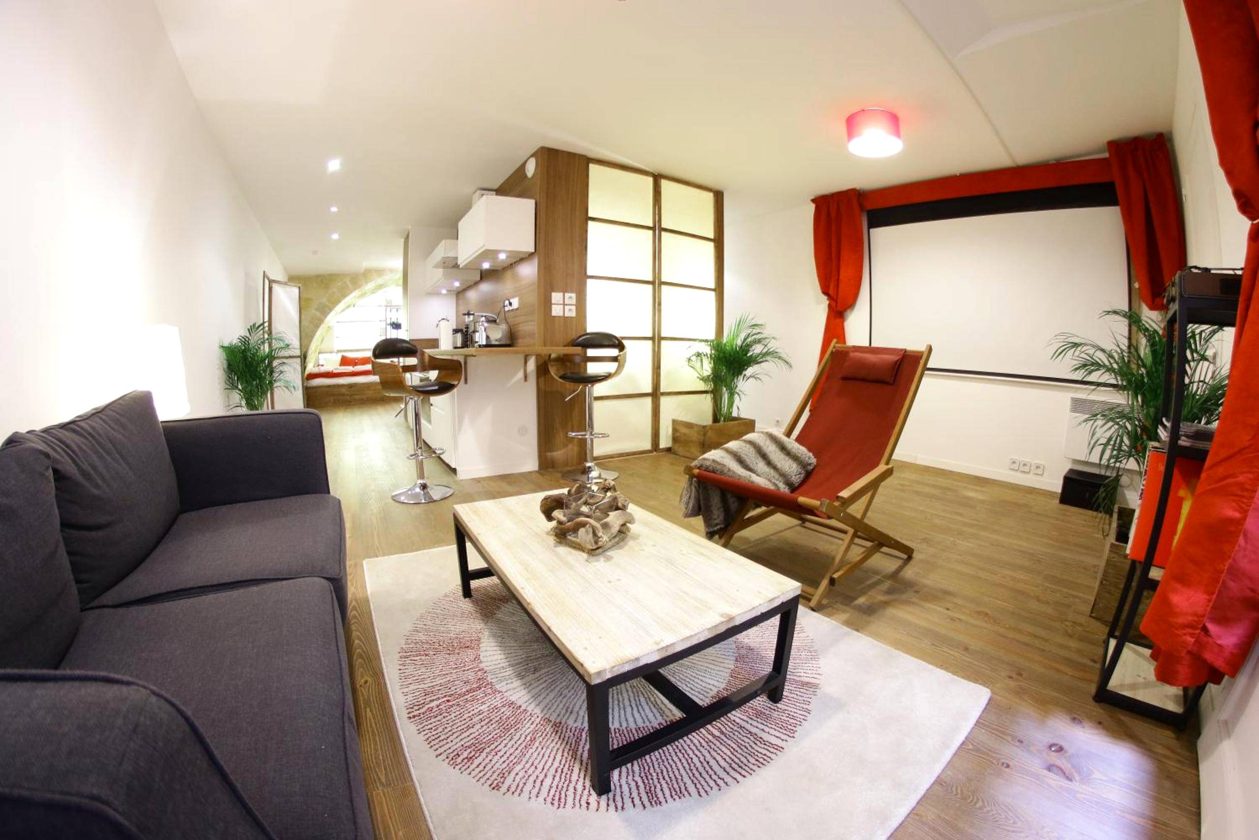 Salon avec canapé, transat et écran de projection - Loft & Spa