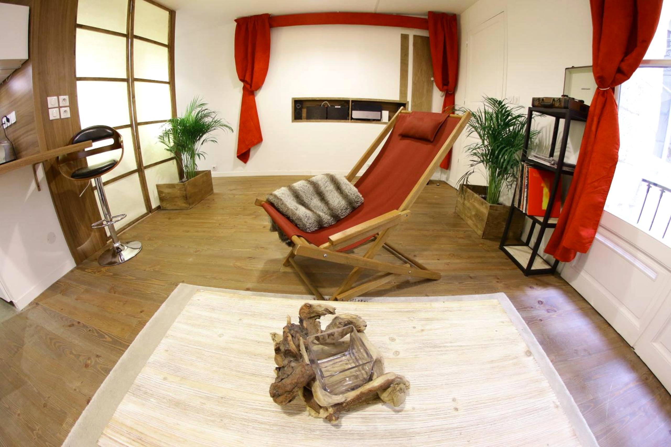 Transat rouge et plantes vertes dans le salon - Loft & Spa