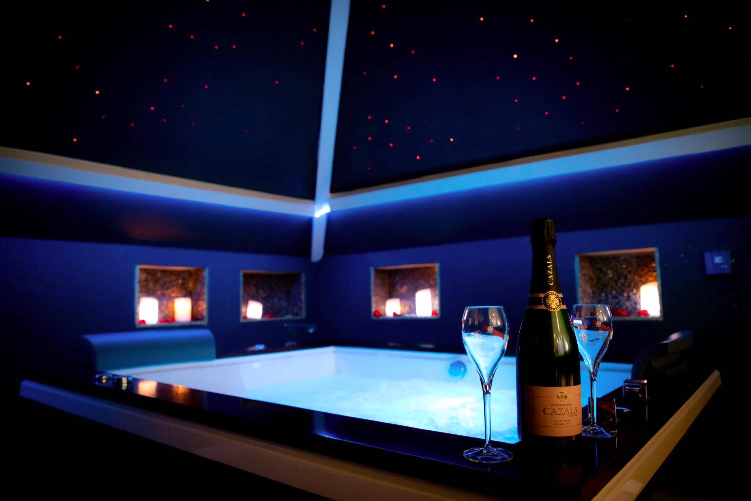 Bouteille de champagne devant jacuzzi éclairé - Le Loft de Zoé