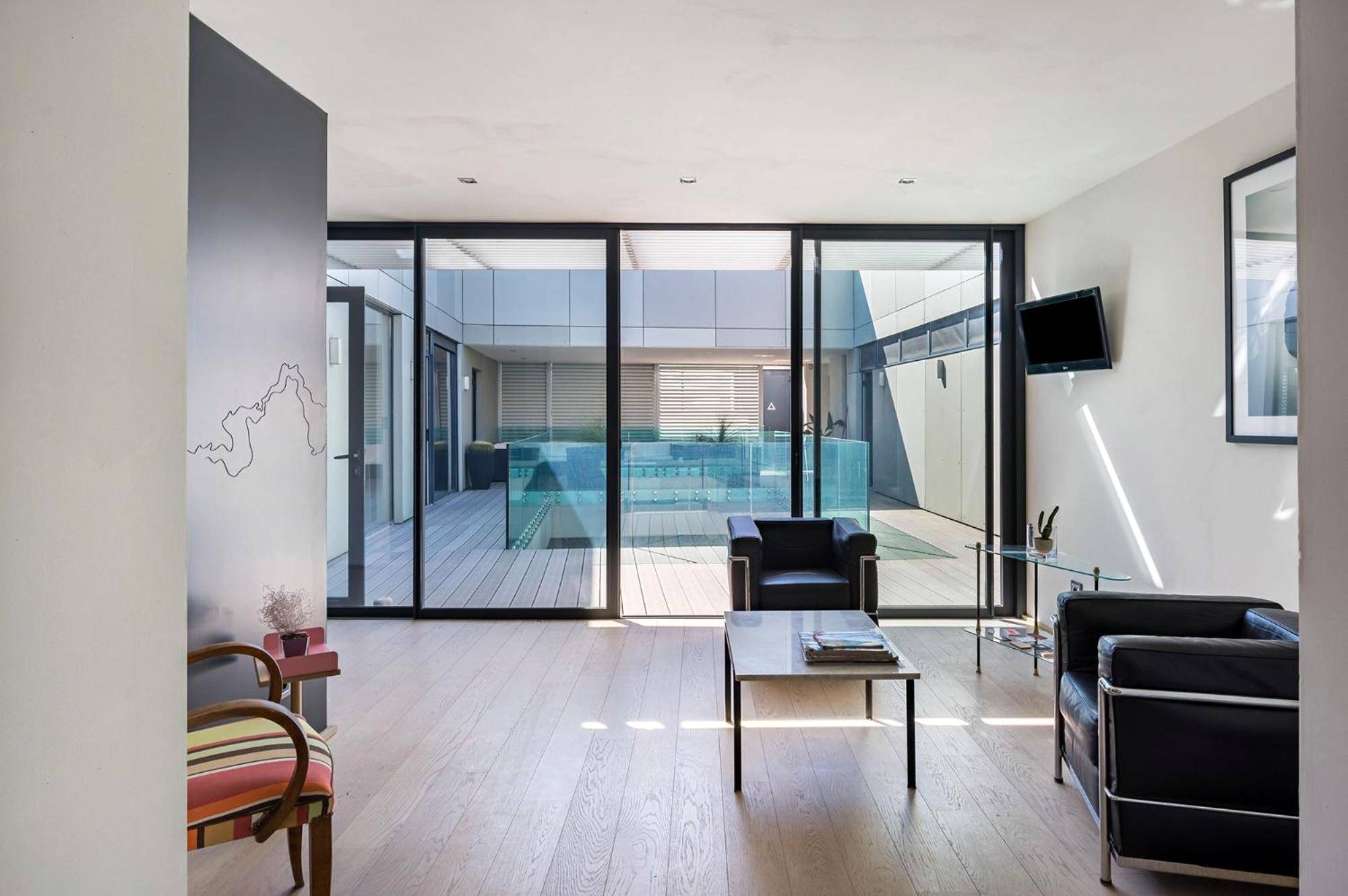 Salon lumineux avec vue sur patio privatif - Love Room Perpignan - La Loge de mer, Lodge urbain