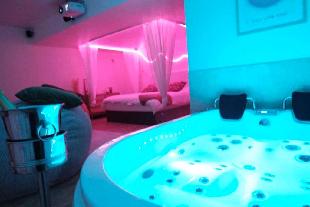 Jacuzzi et lit avec éclairage néon rose - Love Room Charenton - le - Pont - Logement amoureux de luxe collé à PARIS