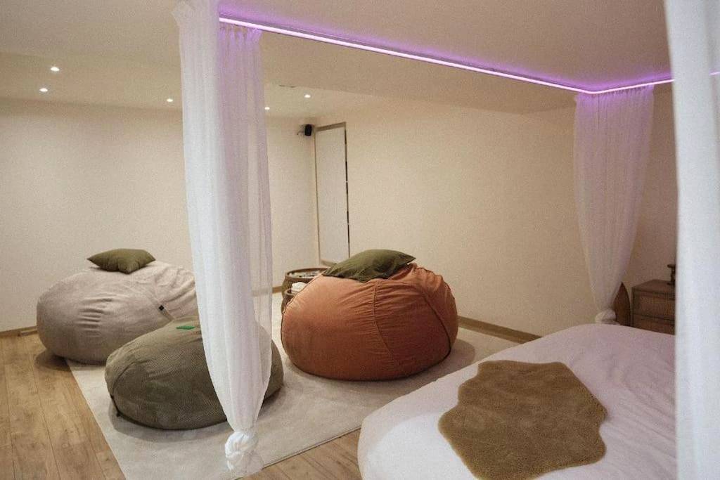 Espace détente avec poufs et lit à baldaquin - Logement amoureux de luxe collé à PARIS