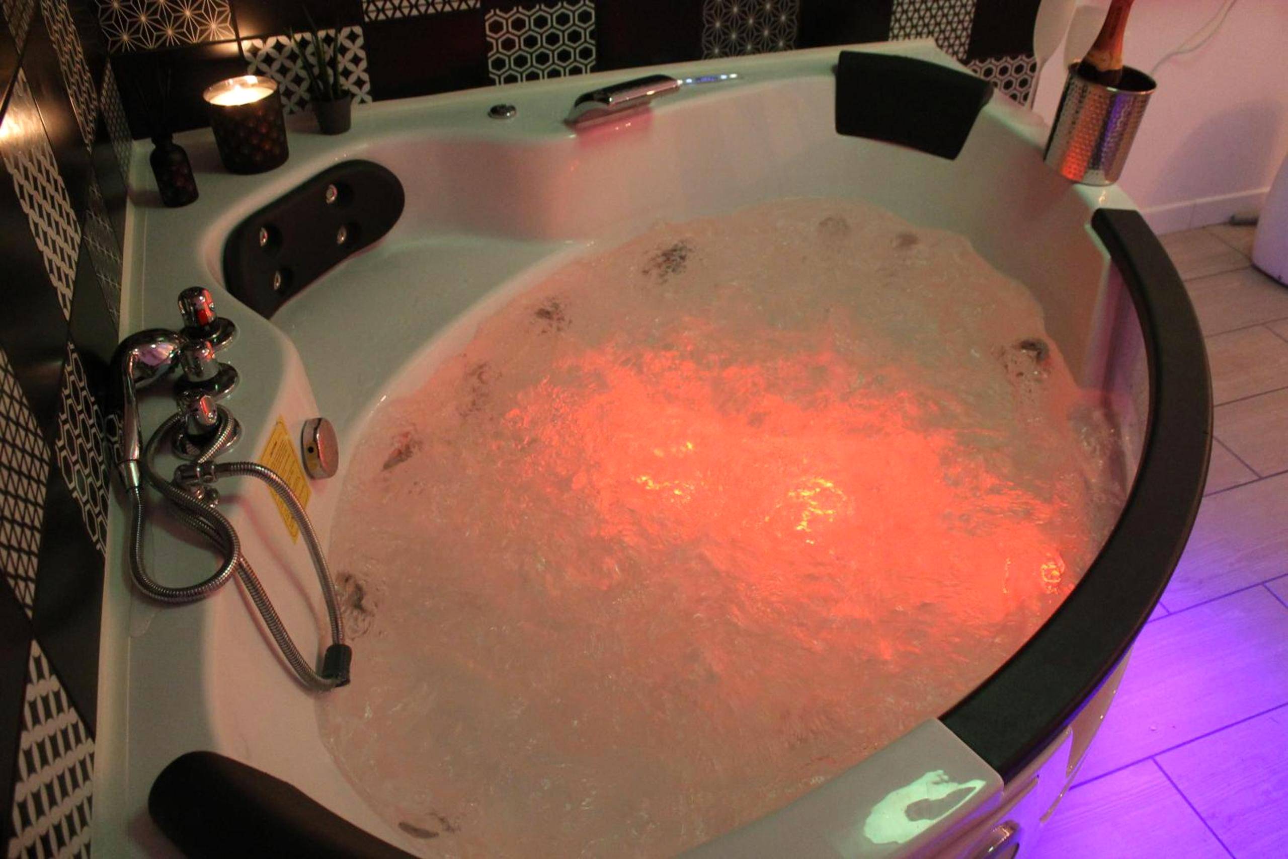 Jacuzzi bouillonnant avec éclairage rouge - L'Écrin du Bien - Le logis du bien - être, balnéo & sauna dans chambre