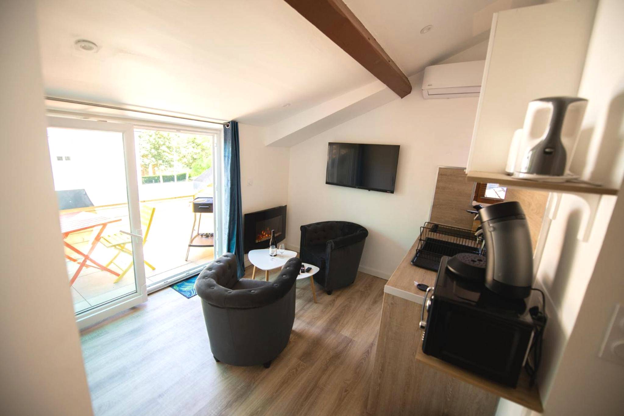 Espace salon avec fauteuils et coin cuisine - Lova Spa Saint - Etienne