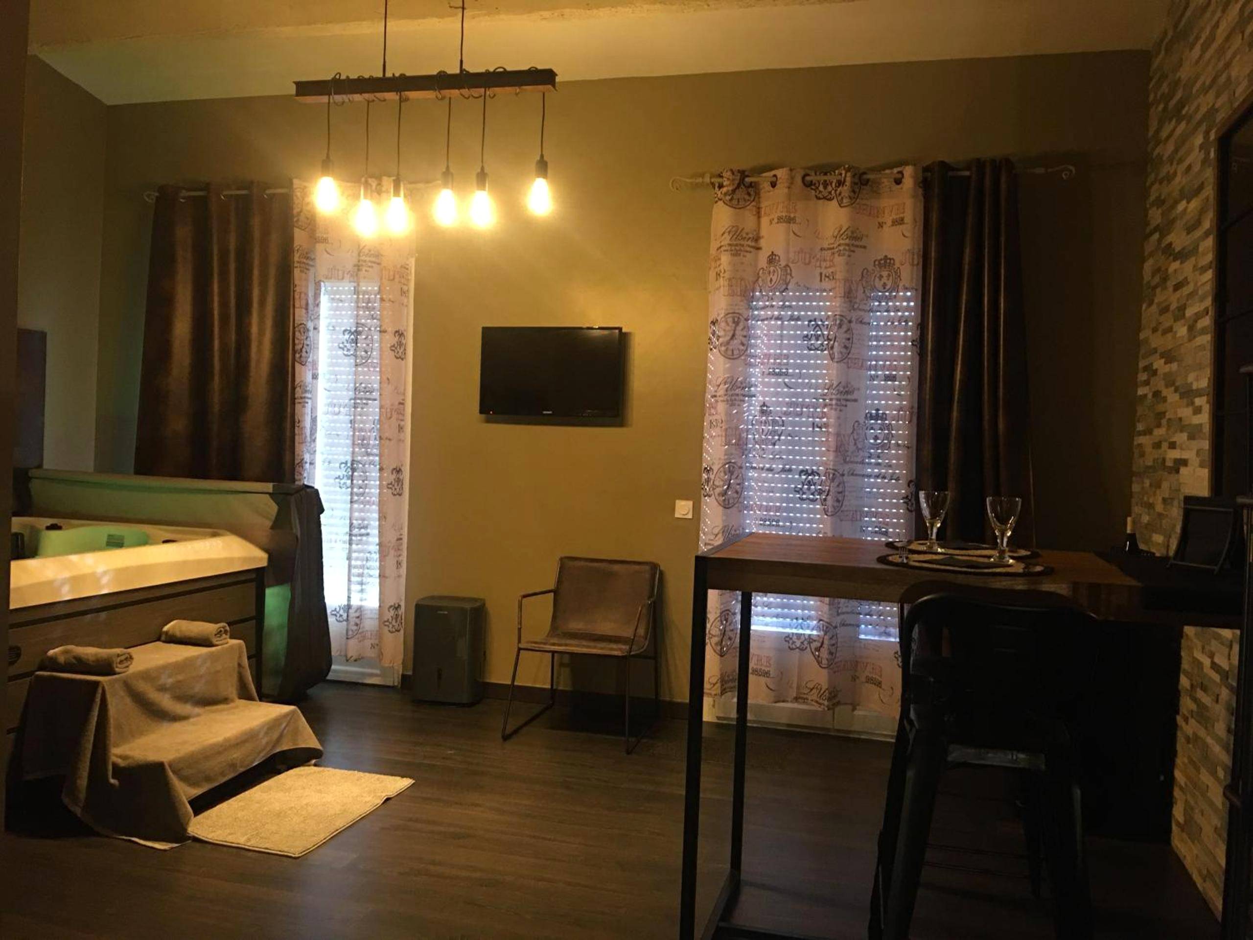 Salon avec jacuzzi et coin repas - Love and Spa