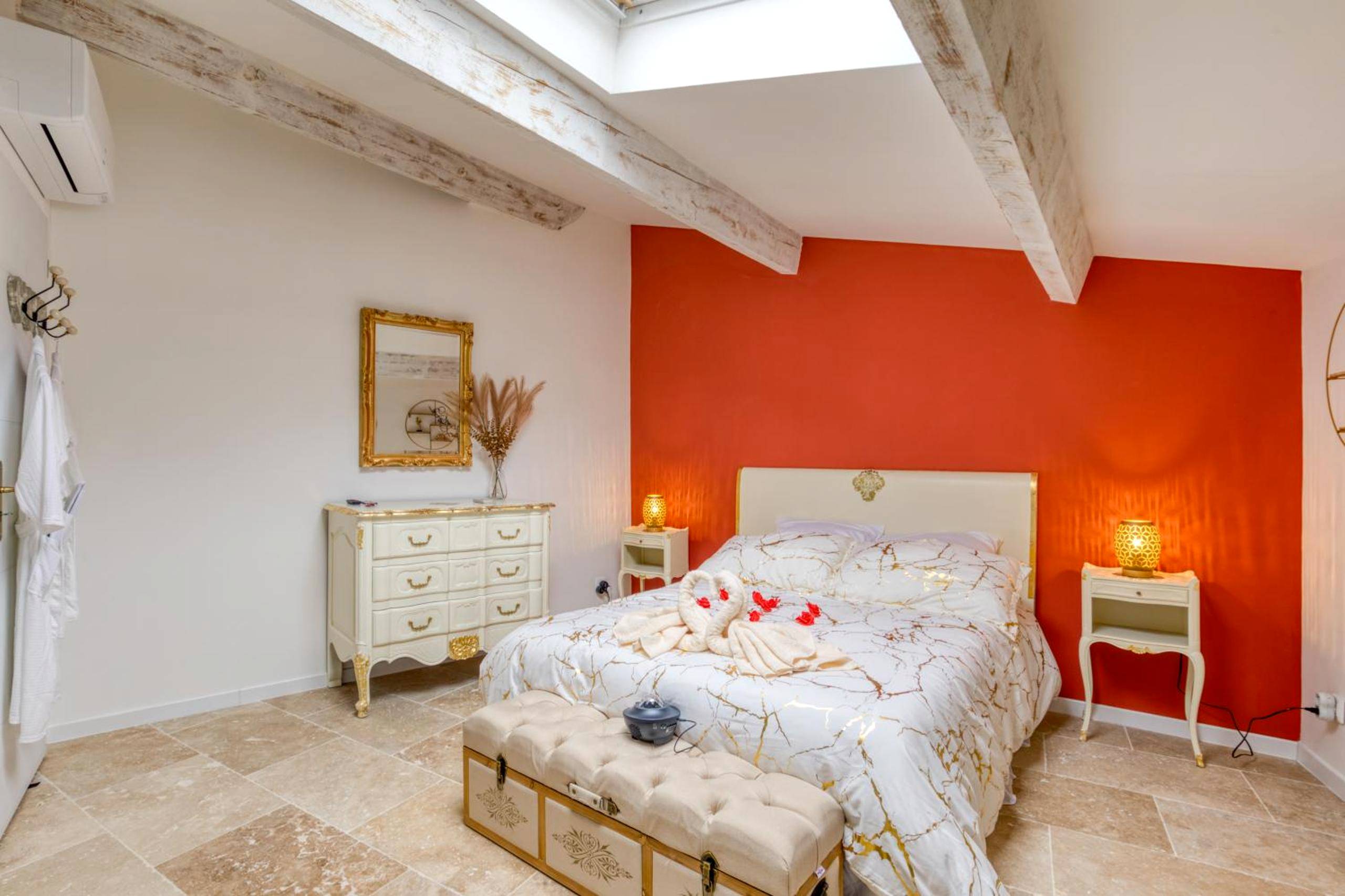 Chambre avec lit décoré et mur rouge - Le love baroque